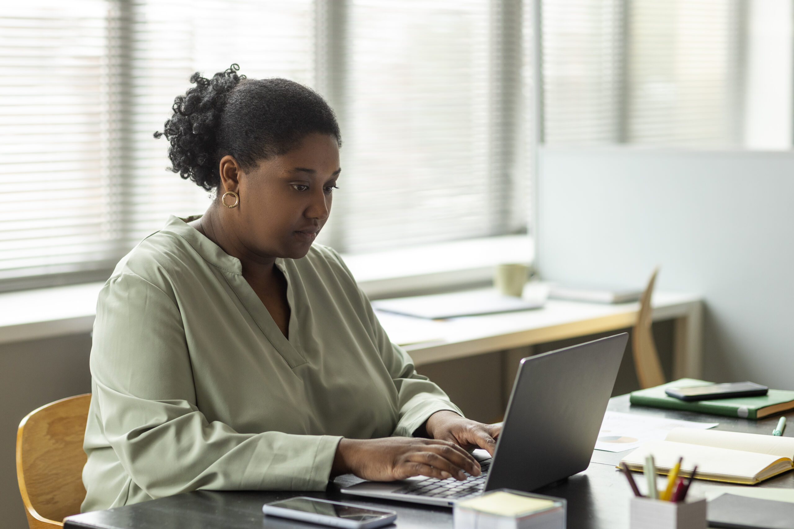 side view of a woman using her laptop - HR - BizEdge blog