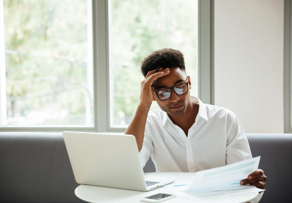 a man looking at a file at his desk - Payroll Decisions - BizEdge blog