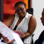 A lady assessing another colleagues task at work - Performance management software - BizEdge Blog