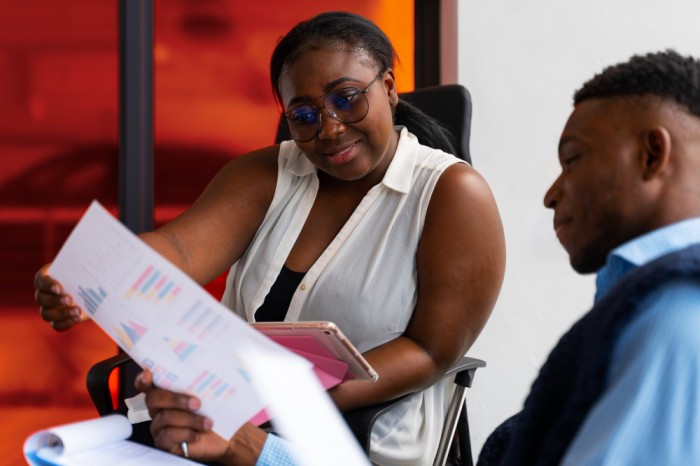 A lady assessing another colleagues task at work - Performance management software - BizEdge Blog