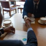 two people exhanging handshake - salary negotiation - BizEdge blog