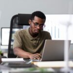 a man on his laptop - performance management software - BizEdge blog