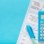 a calculator and a payslip - Payroll management system - BizEdge blog