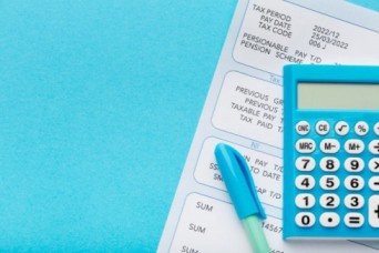 a calculator and a payslip - Payroll management system - BizEdge blog