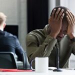 Upset african man with hand on his head - Workplace Investigation - BizEdge blog