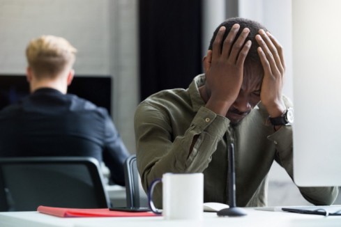 Upset african man with hand on his head - Workplace Investigation - BizEdge blog