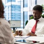 a man at his desk writing - 5 Interview Questions That Reveal Culture Fit