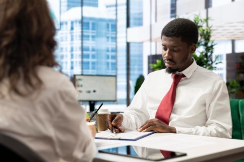 a man at his desk writing - 5 Interview Questions That Reveal Culture Fit