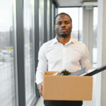 A man carrying a carton that contains his files - How Many Jobs Will AI Replace by 2030