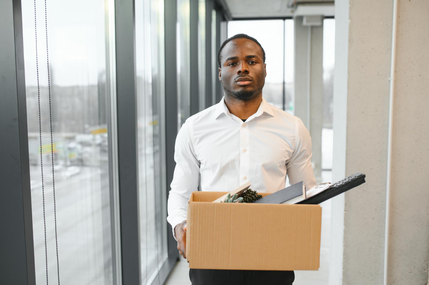 A man carrying a carton that contains his files - How Many Jobs Will AI Replace by 2030