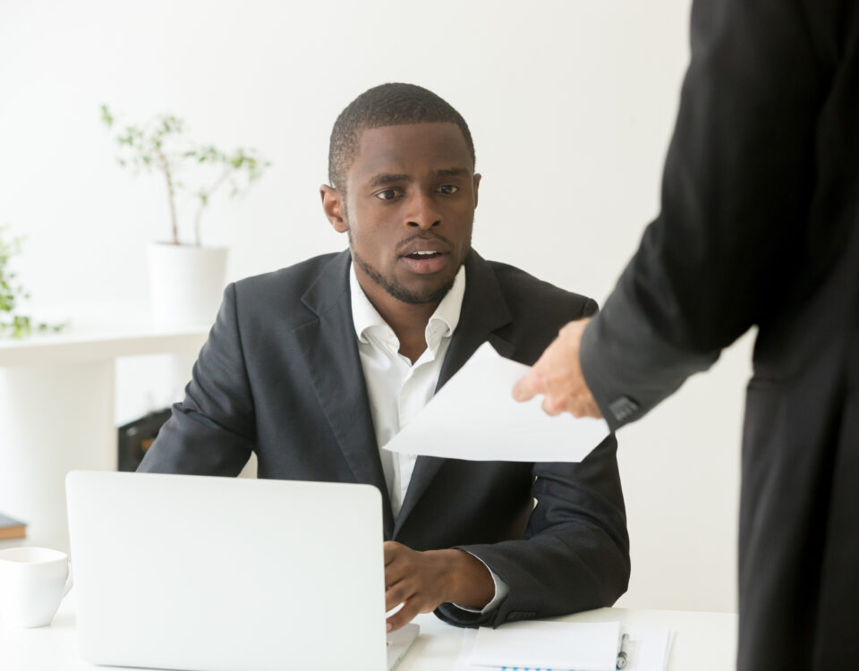 Surprised businessman getting unexpected resignation letter from a colleague